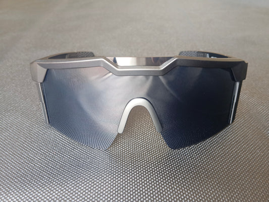 Dark sunglasses seen from the front. Comfortable black nose-pad visible. Polycarbonate lens is tinted black.