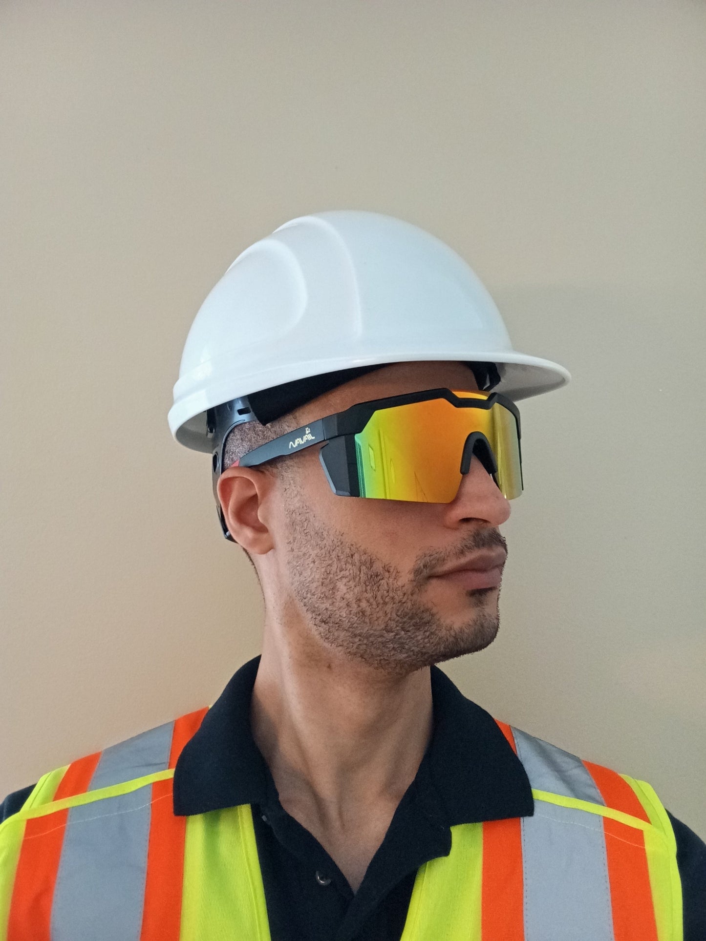 A worker equipped with safety helmet and high visibility vest is wearing safety sunglasses.