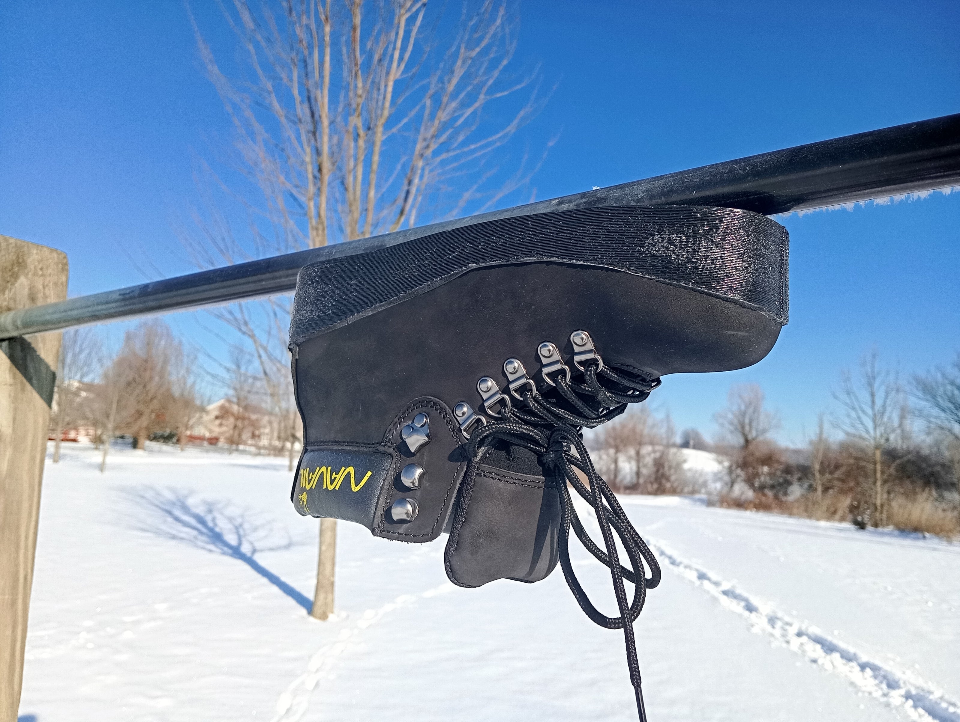 A magnetic boot is placed upside down under a round metal pole. 